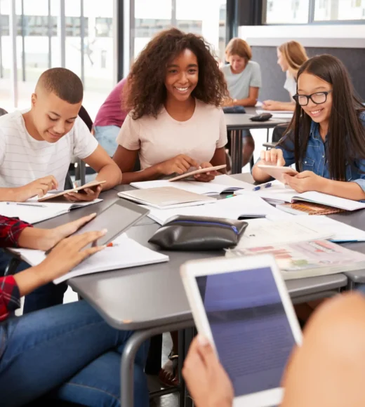 teacher-sitting-with-high-school-students-using-ta-2023-11-27-05-22-30-utc